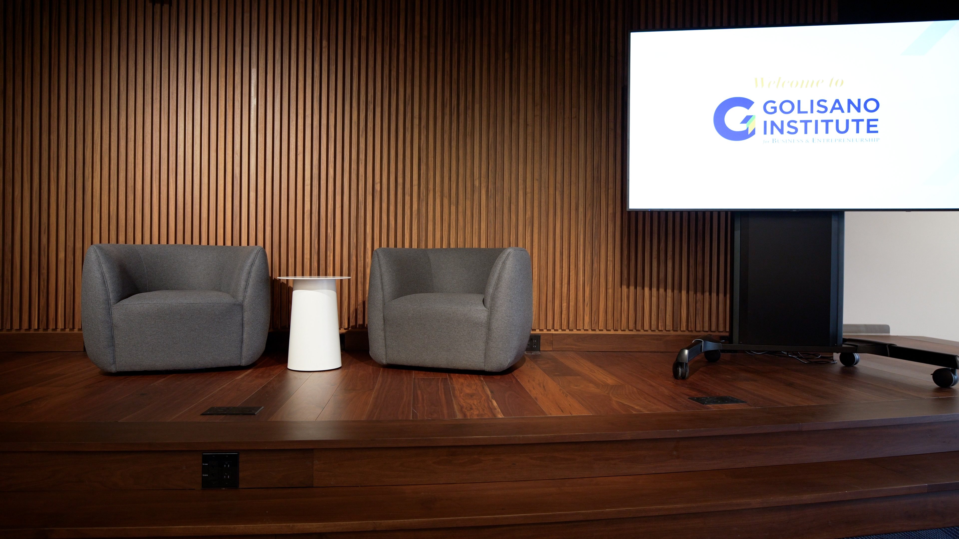 Curved wood-tone feature wall in the AI Innovation Hub at Golisano Institute.